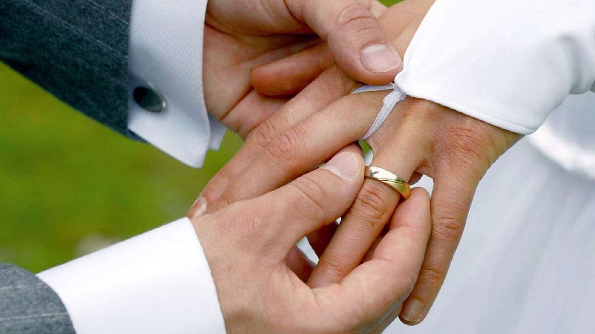 Eine Ehepaar bei einer Hochzeit, die sich die Ringe anlegen