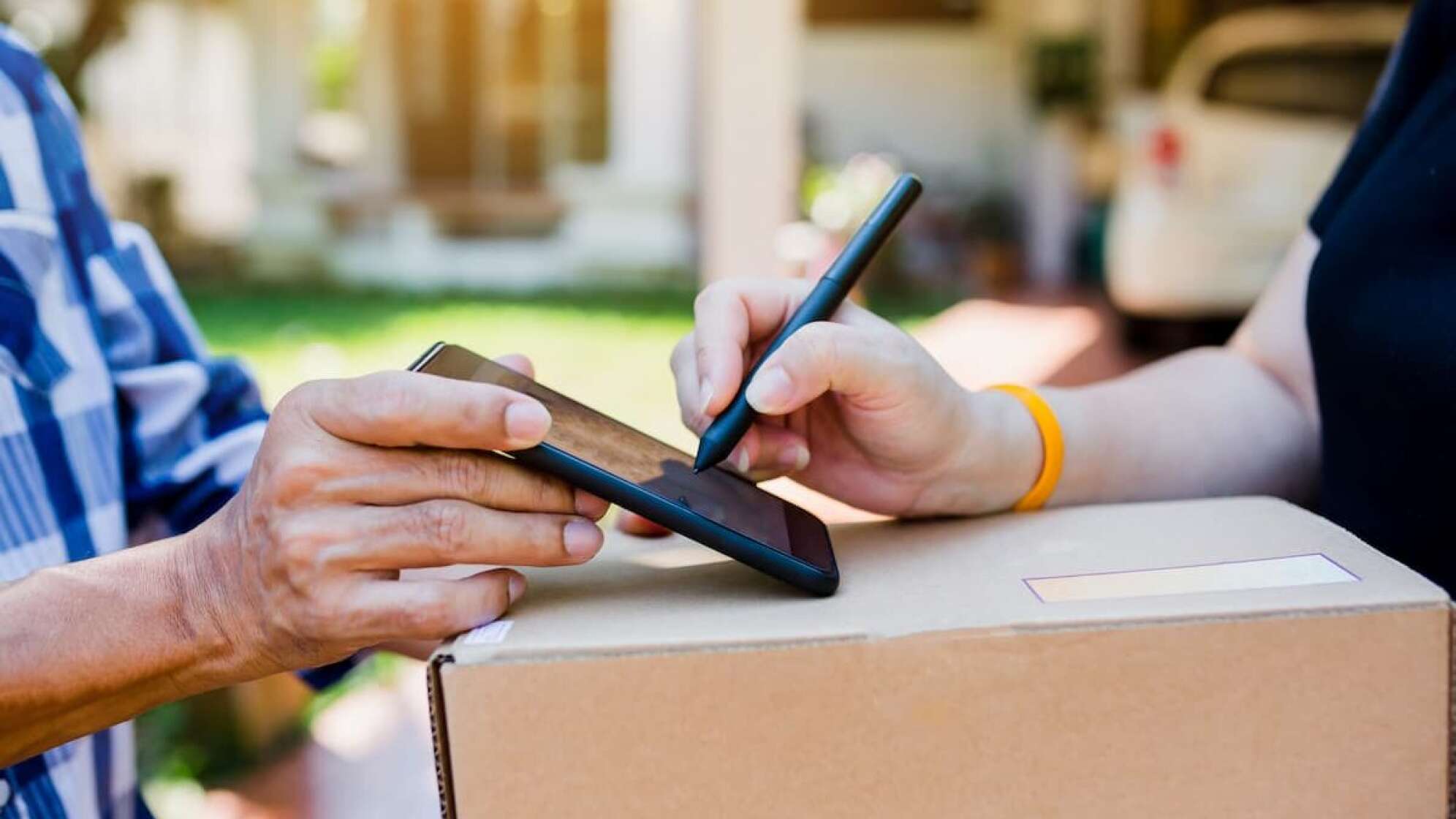 Person unterschreibt die Paketannahme