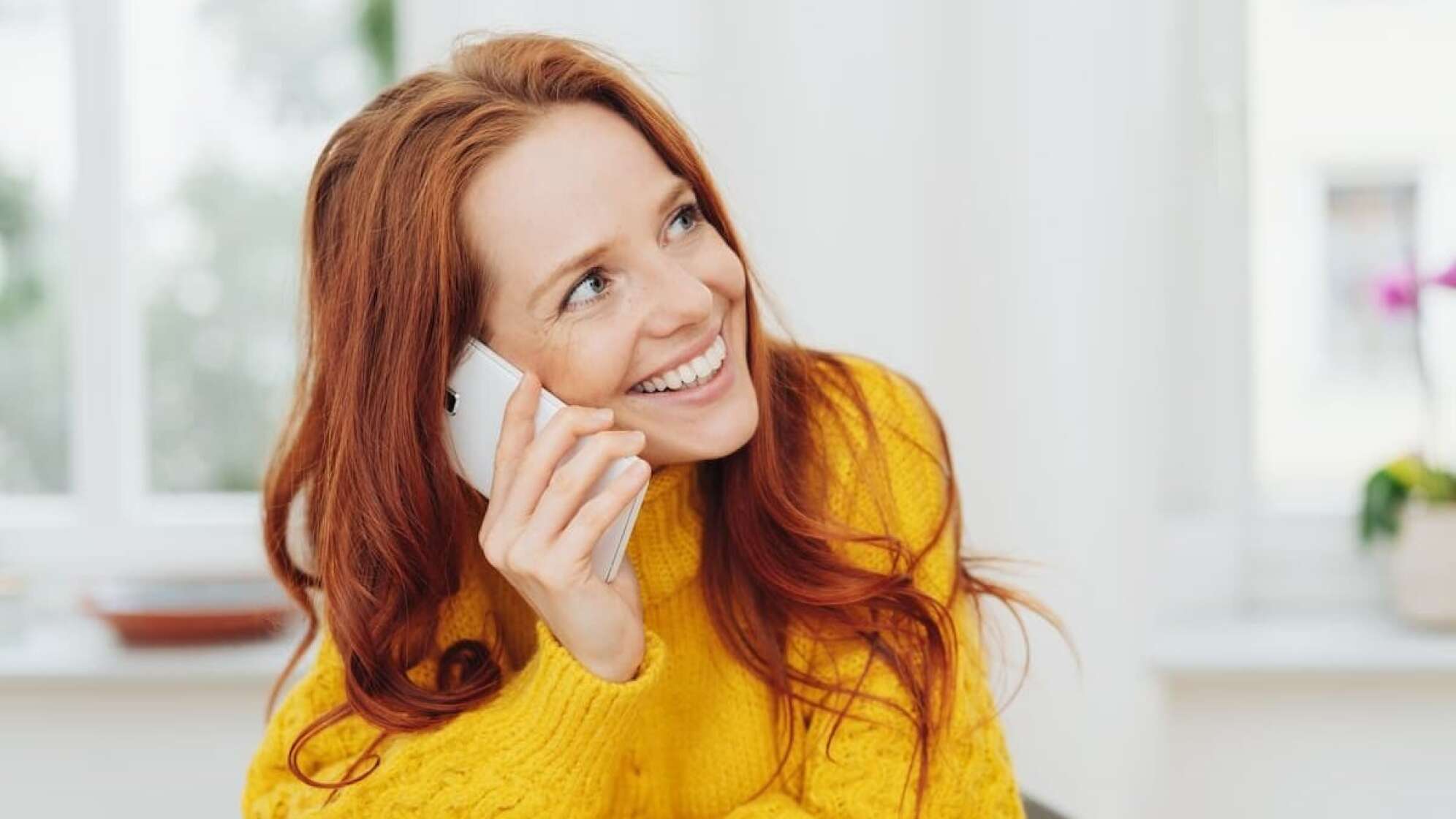 Rothaarige Frau beim Telefonieren