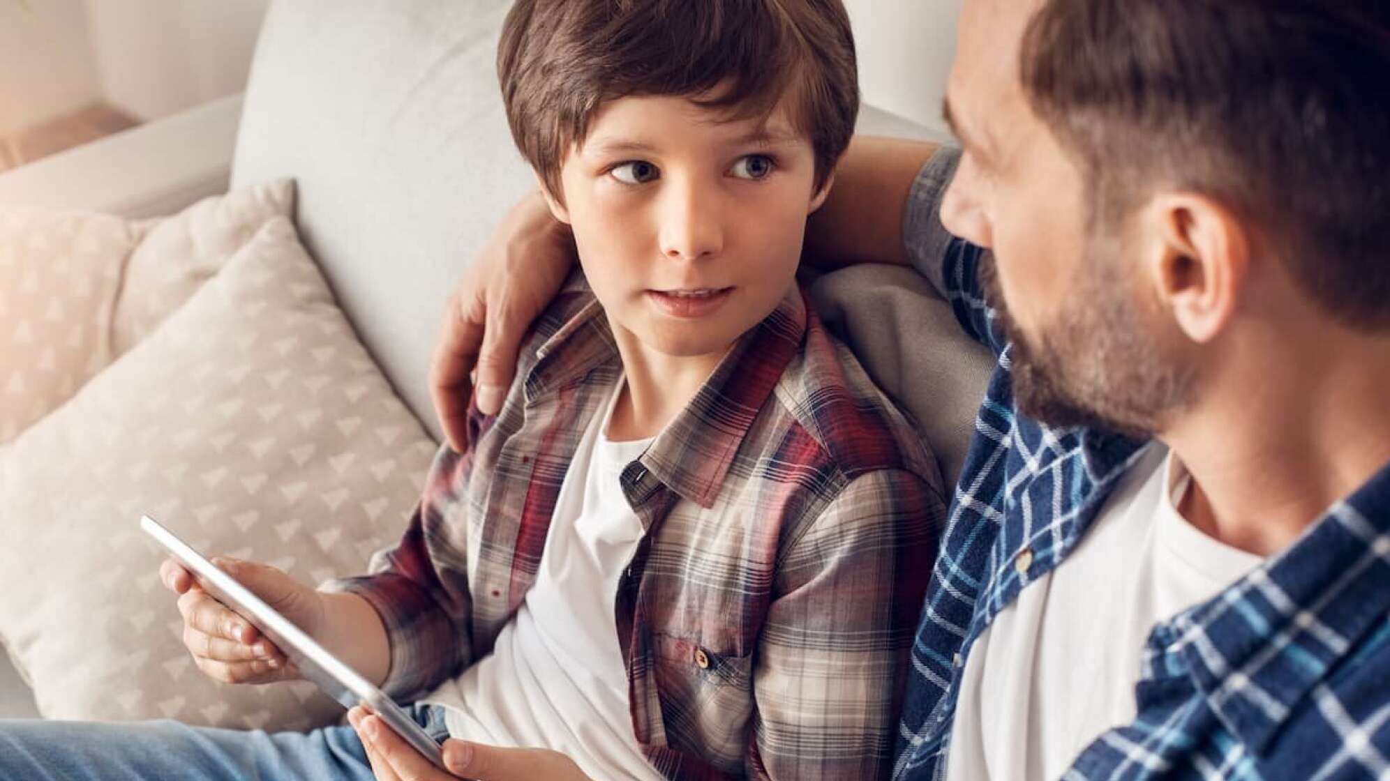 Ernstes Gespräch zwischen Vater und Kind am iPad