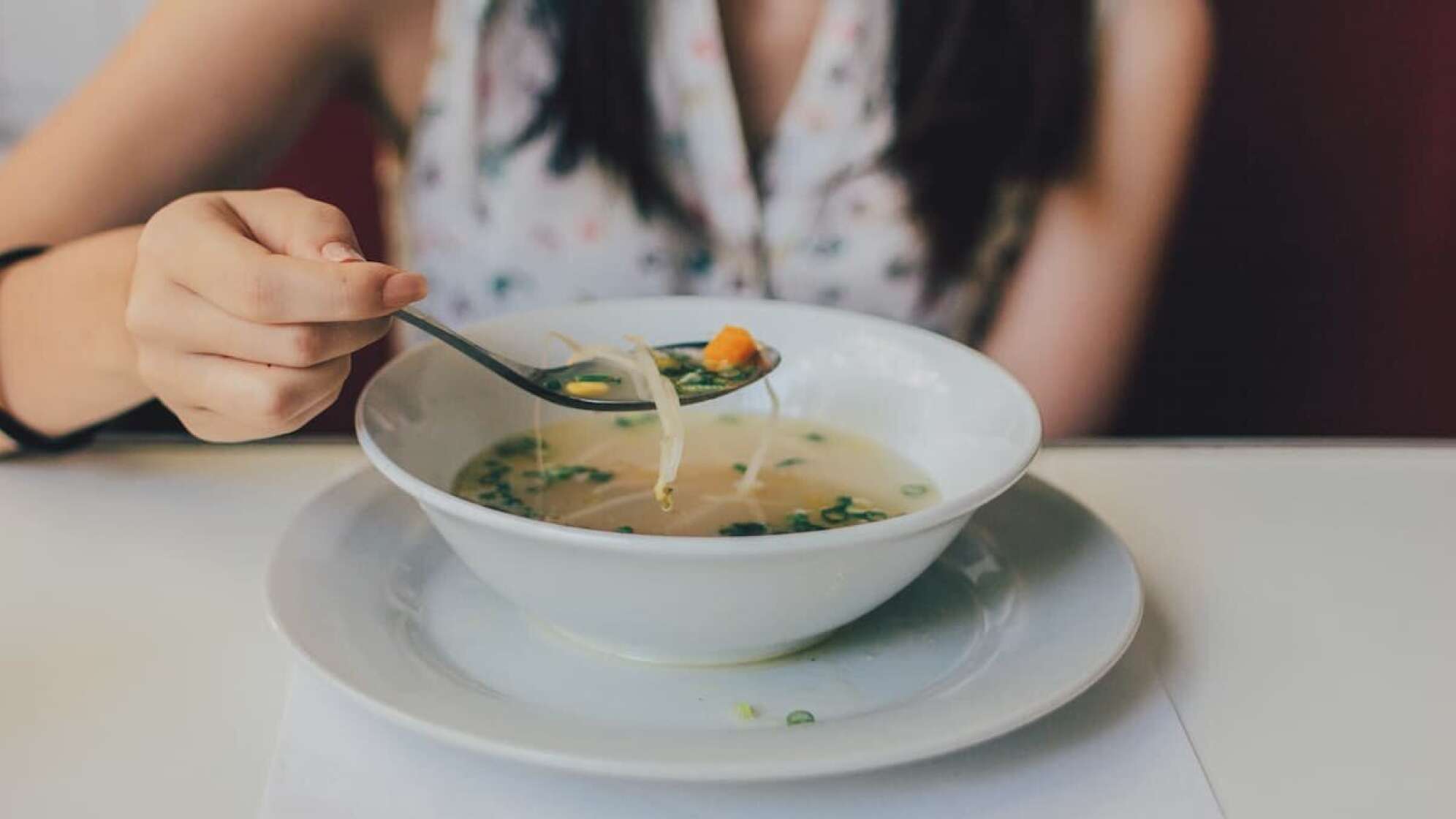 Eine Frau, die eine Suppe isst