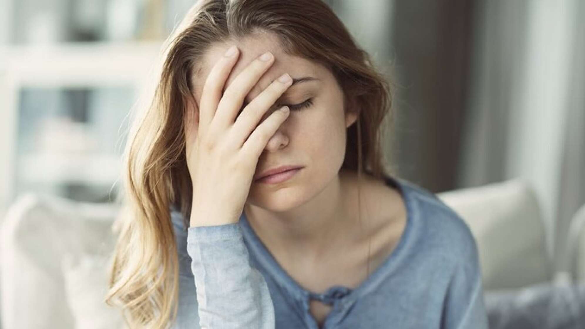 Frau hält Hand an den Kopf