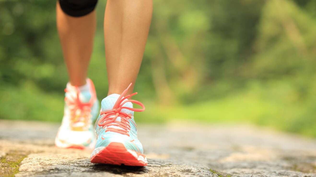 Beine einer Frau, die Laufschuhe trägt