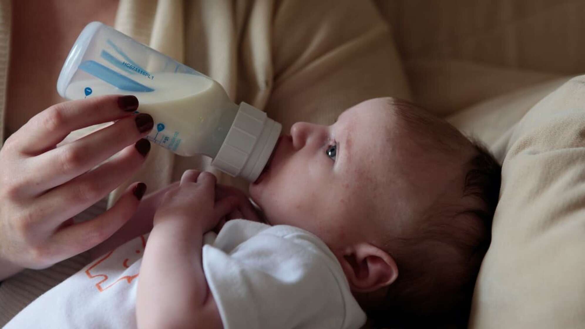 Ein Kind trinkt Milch aus einer Flasche