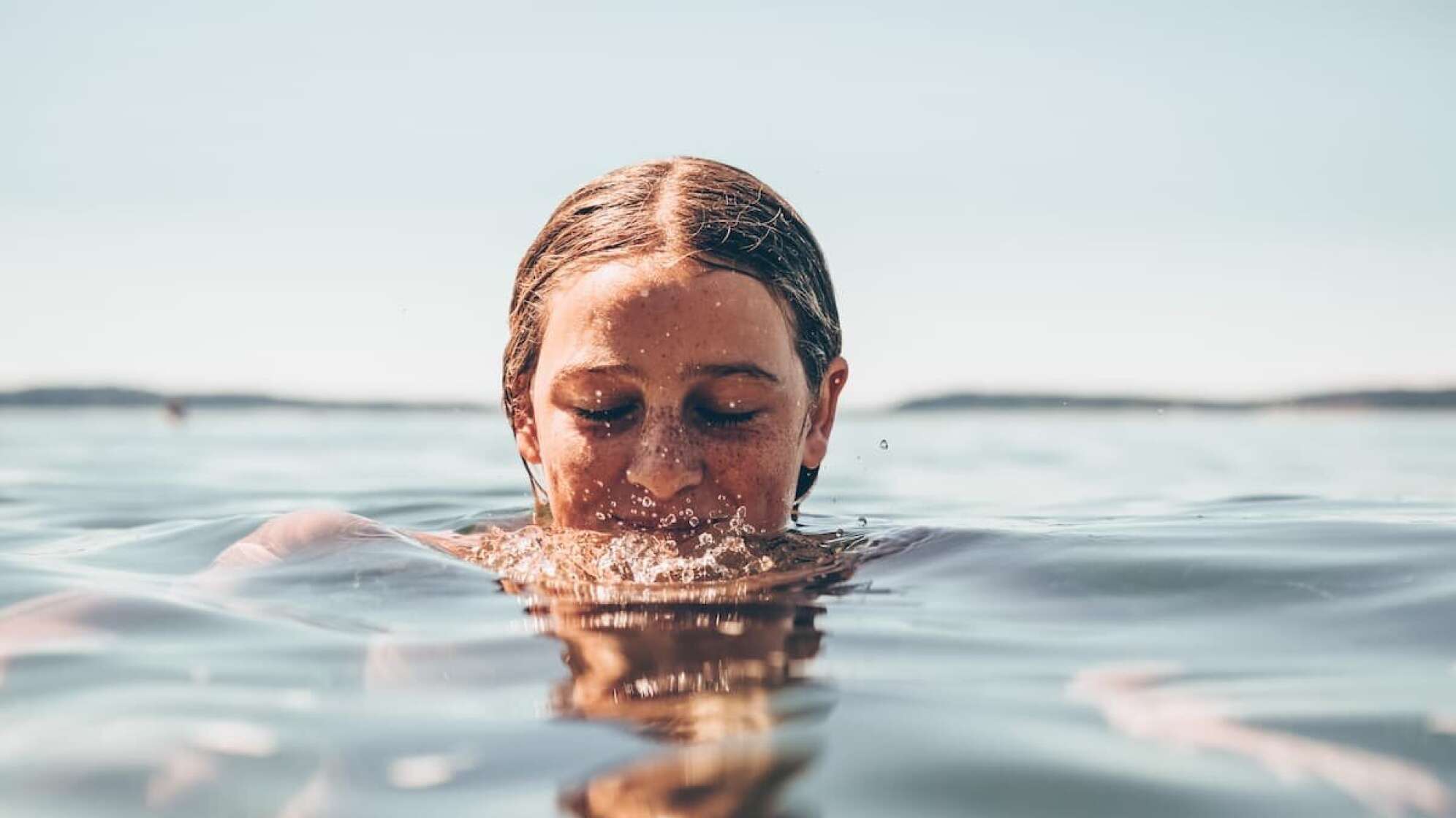 Eine Frau mit Sommersprossen im Wasser