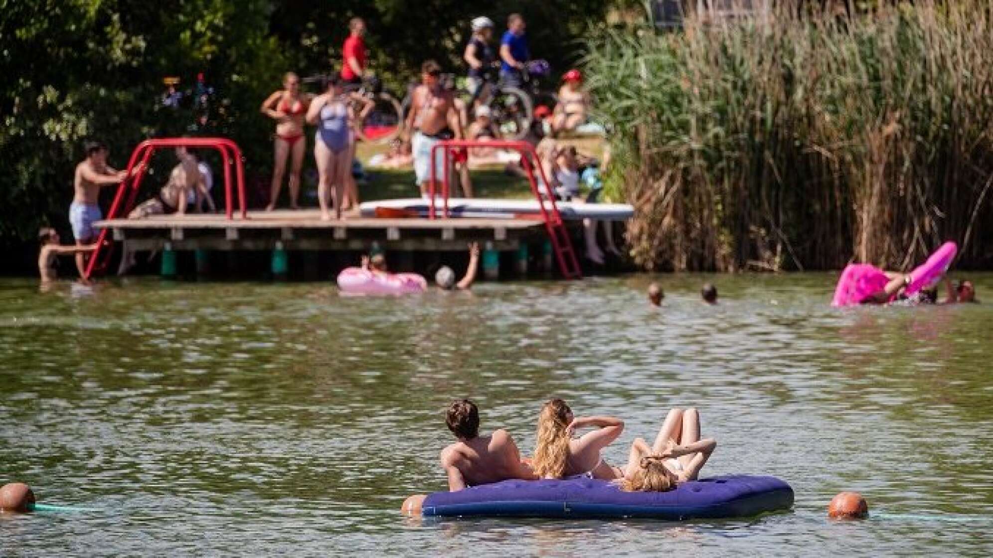 Ein Badesee mit Menschen am Ufer und im Wasser