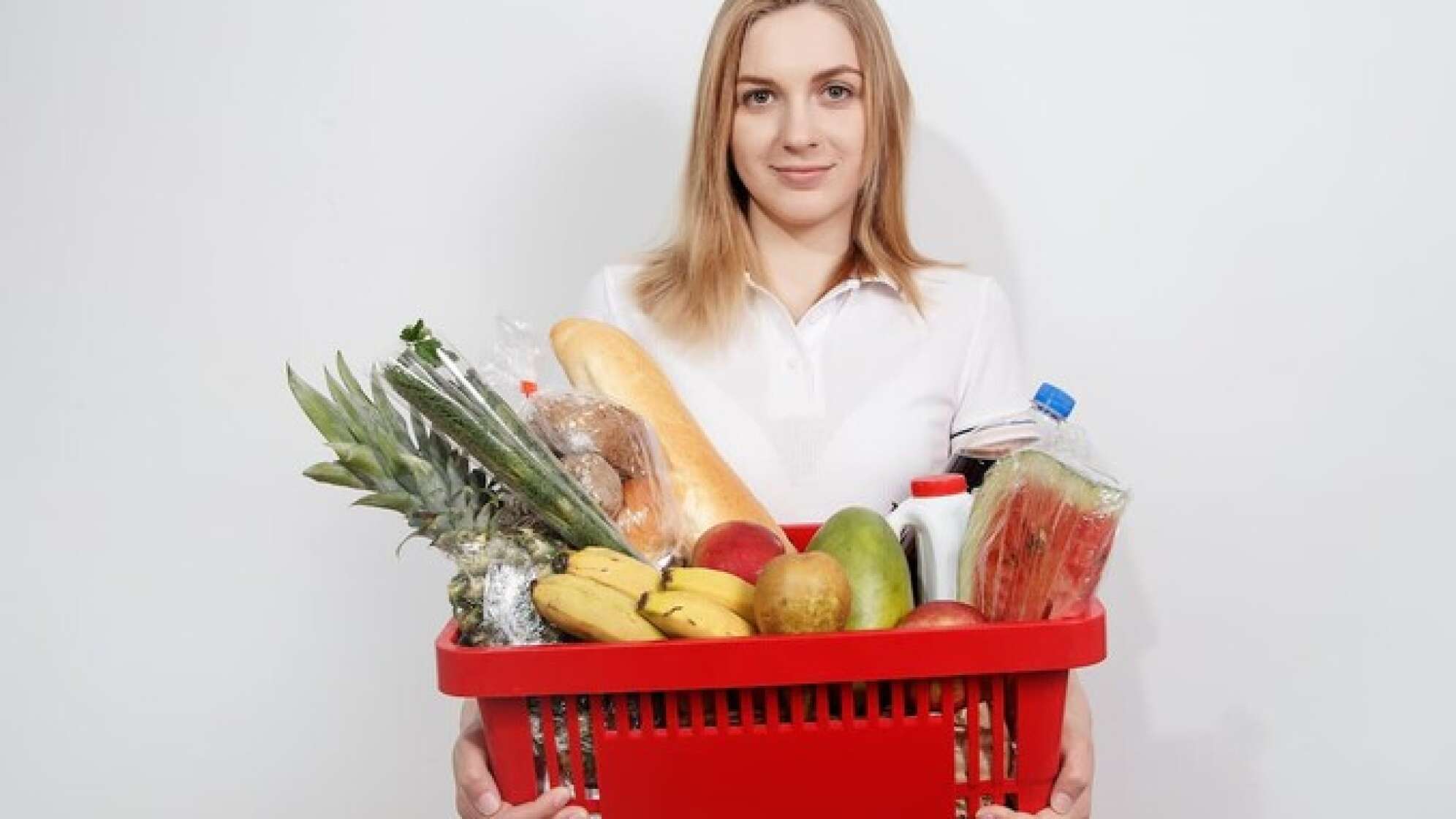 Eine Frau trägt einen vollen Einkaufskorb