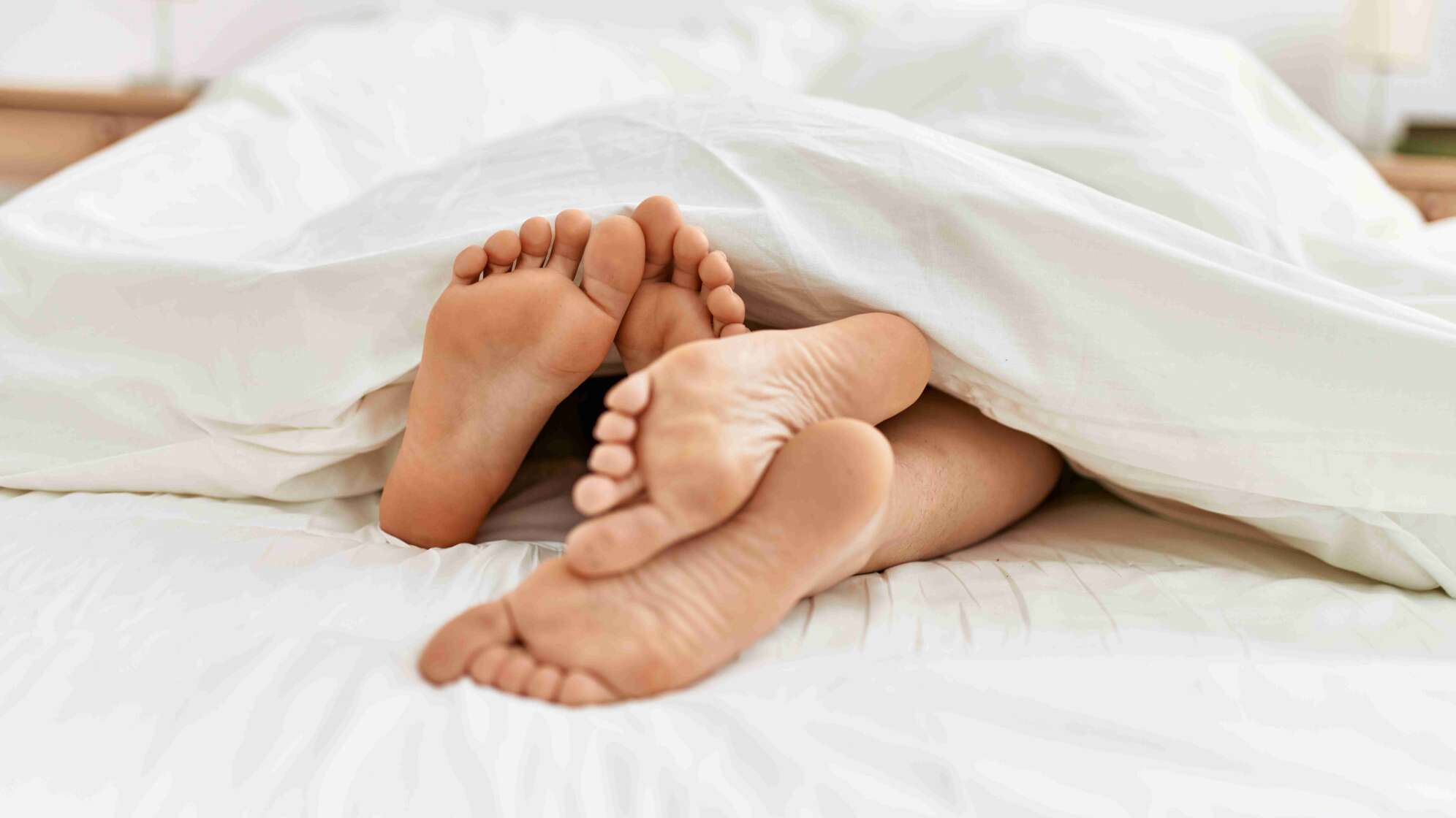 Füße unter Bettdecke