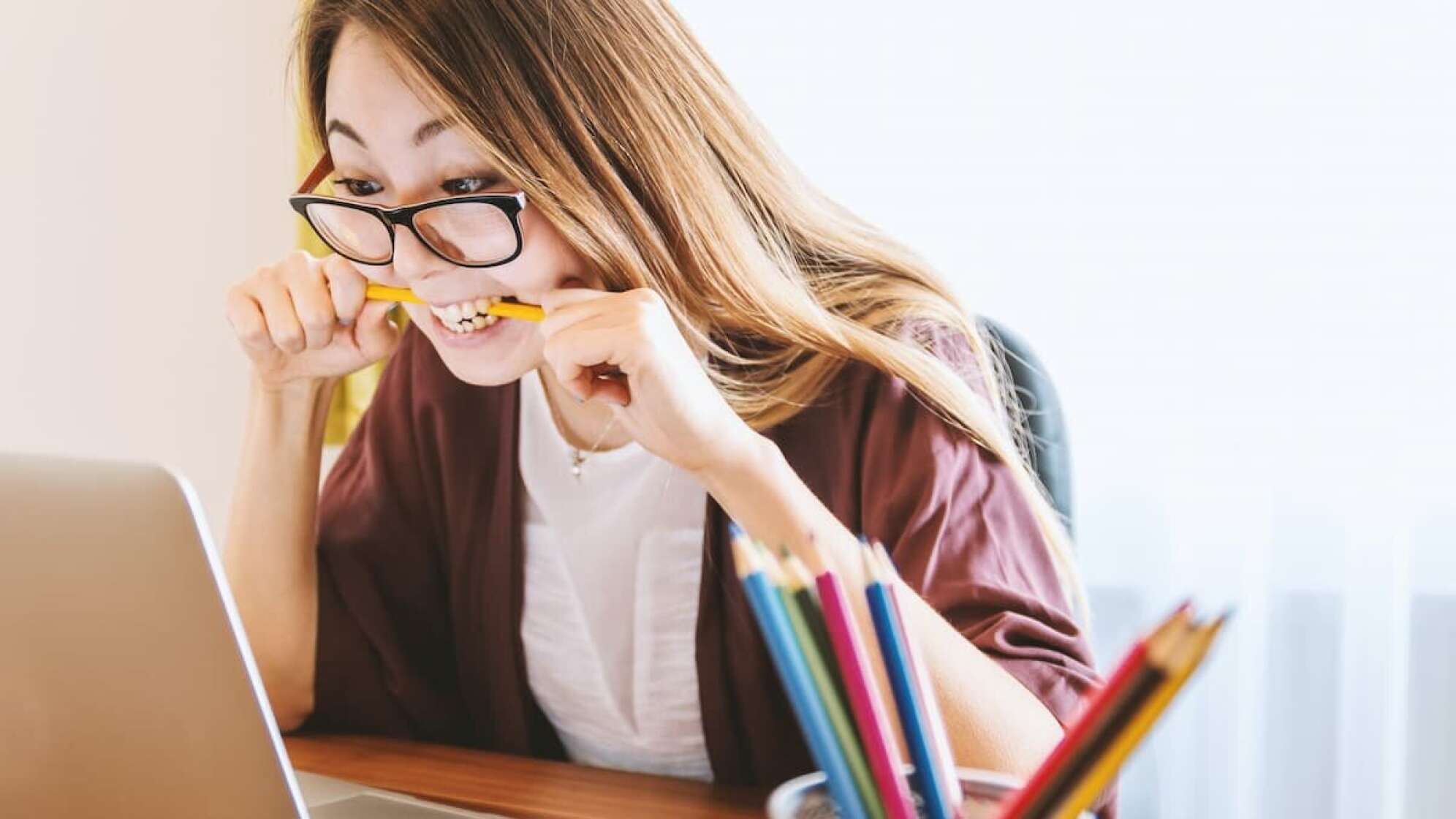 Eine Frau bei der Arbeit, die auf einen Stift beißt