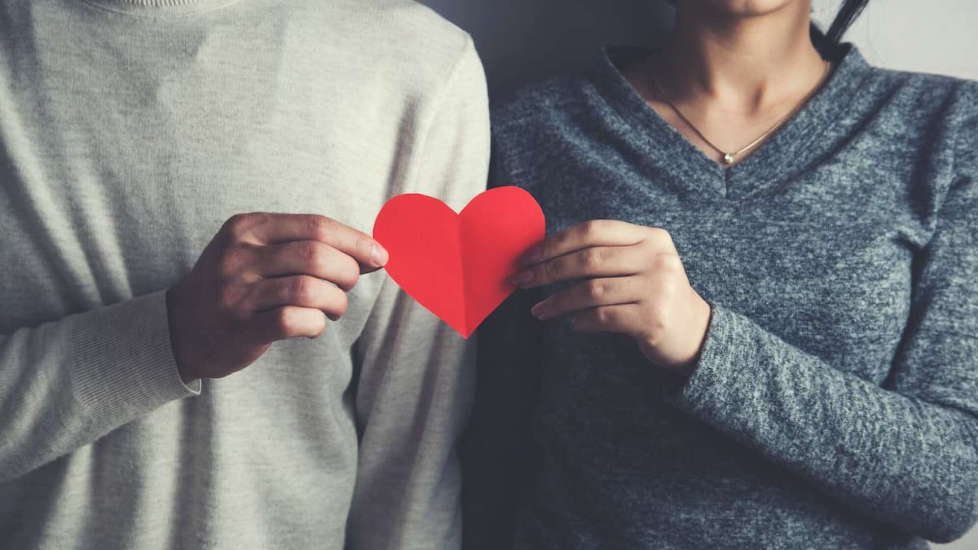 Ein Mann und eine Frau, die ein Herz halten