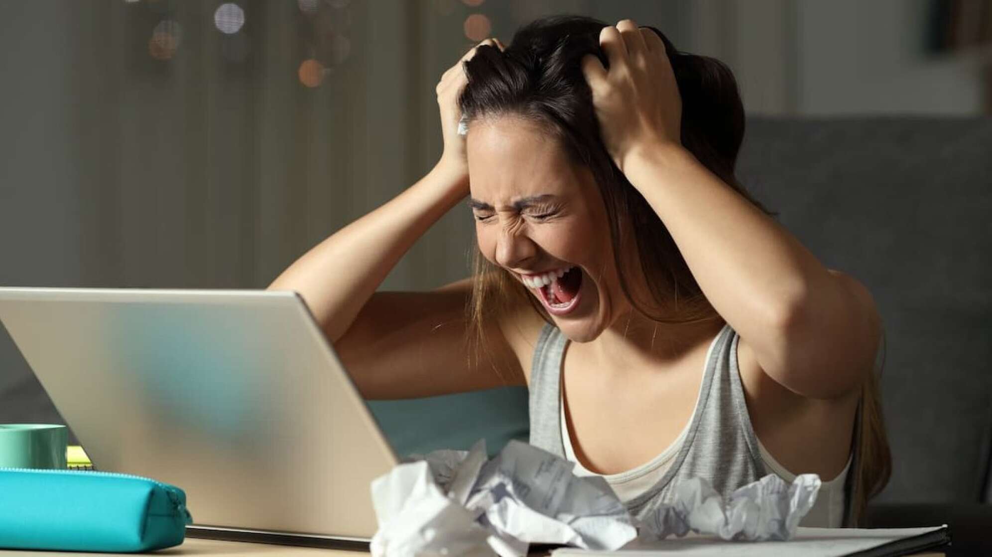 Eine Frau vor einem Laptop, die schreit
