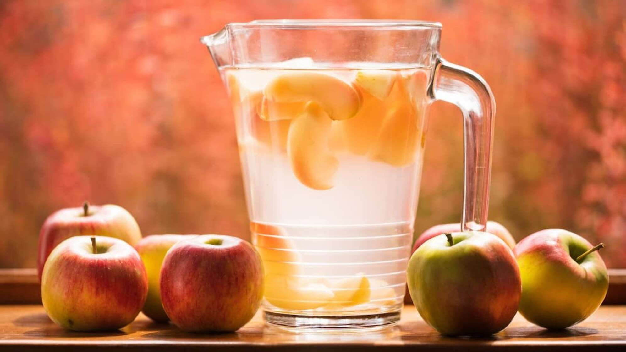 Eine Glaskaraffe und Äpfel auf einem Tisch