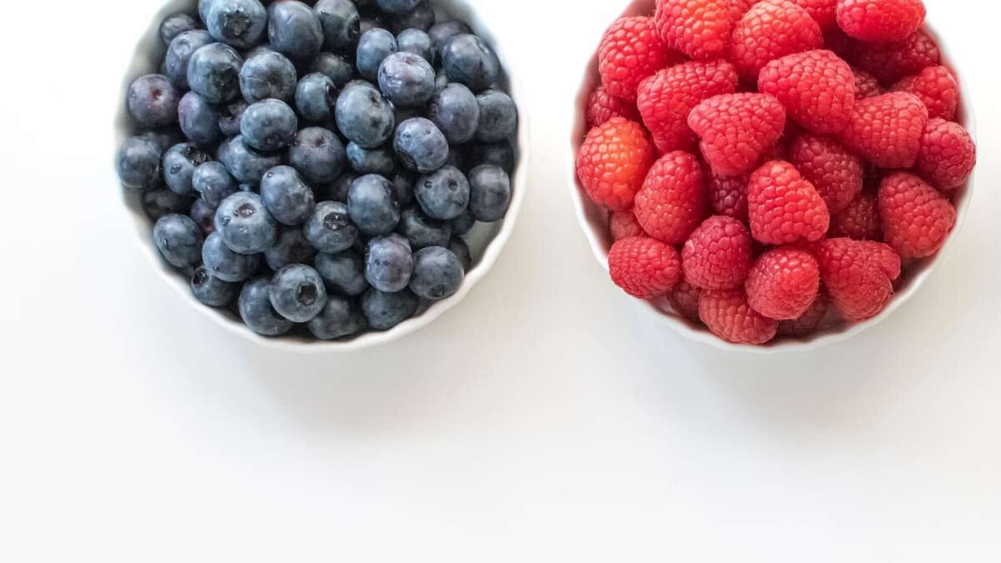 Zwei Schalen mit Blaubeeren und Erdbeeren