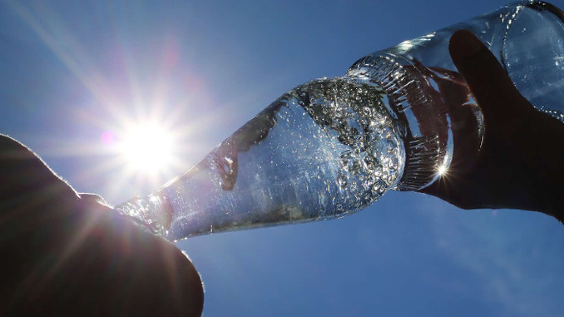 Mensch trinkt Wasser aus Flasche