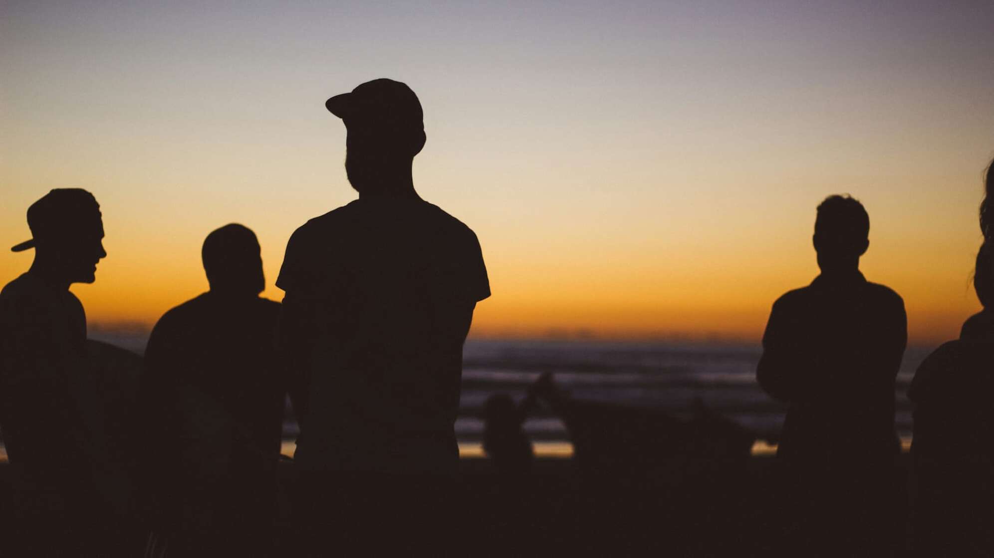 männliche Silhouetten im Sonnenuntergang