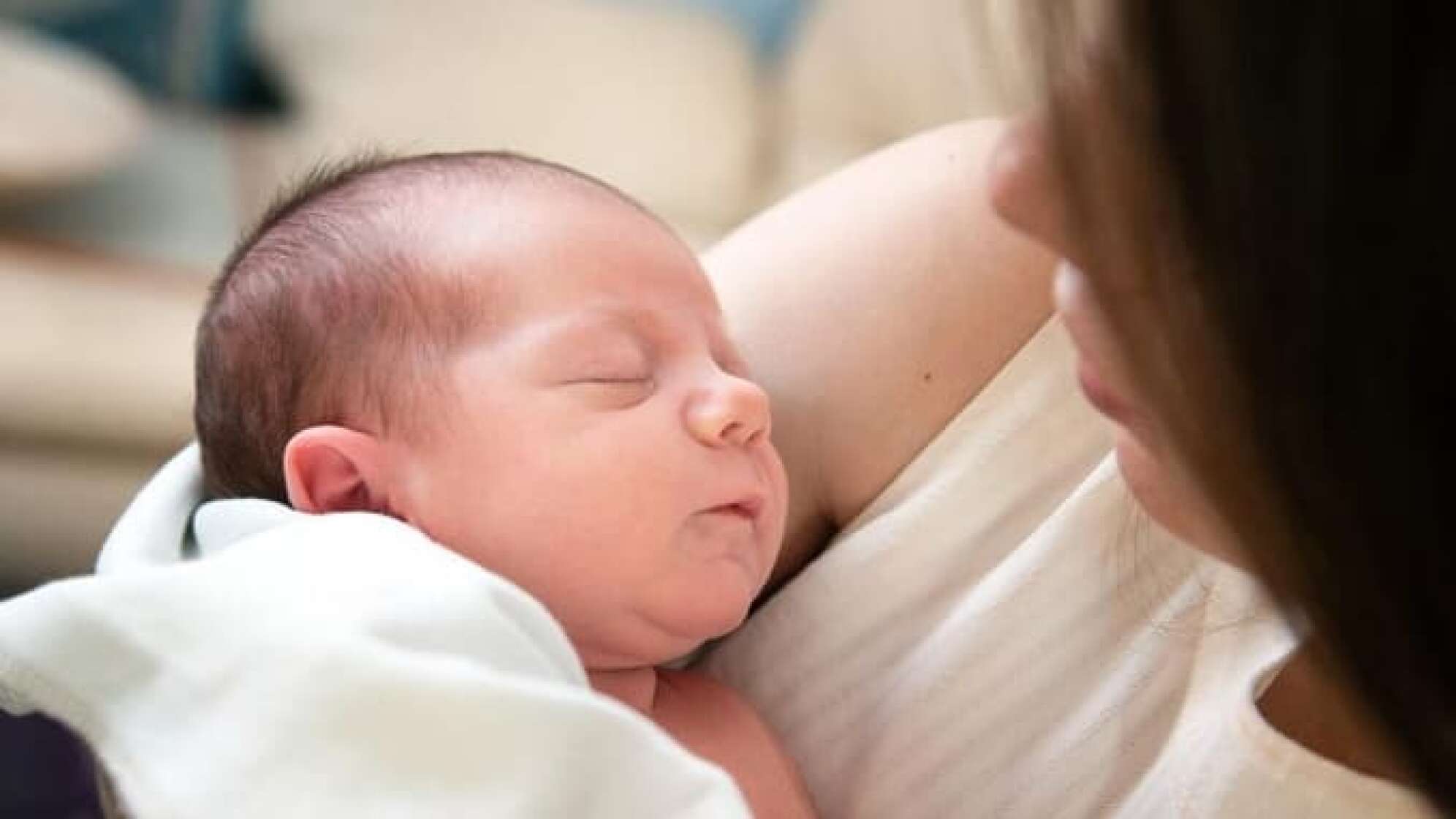 Mutter hält schlafendes Baby