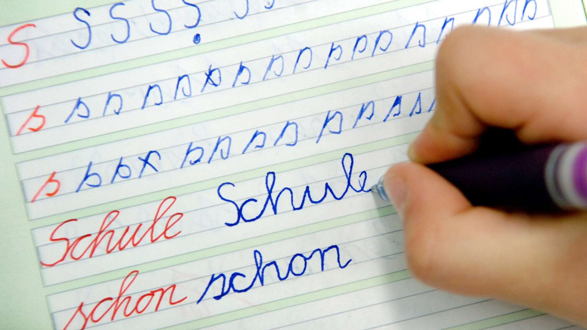 Kind schreibt in Schreibschrift