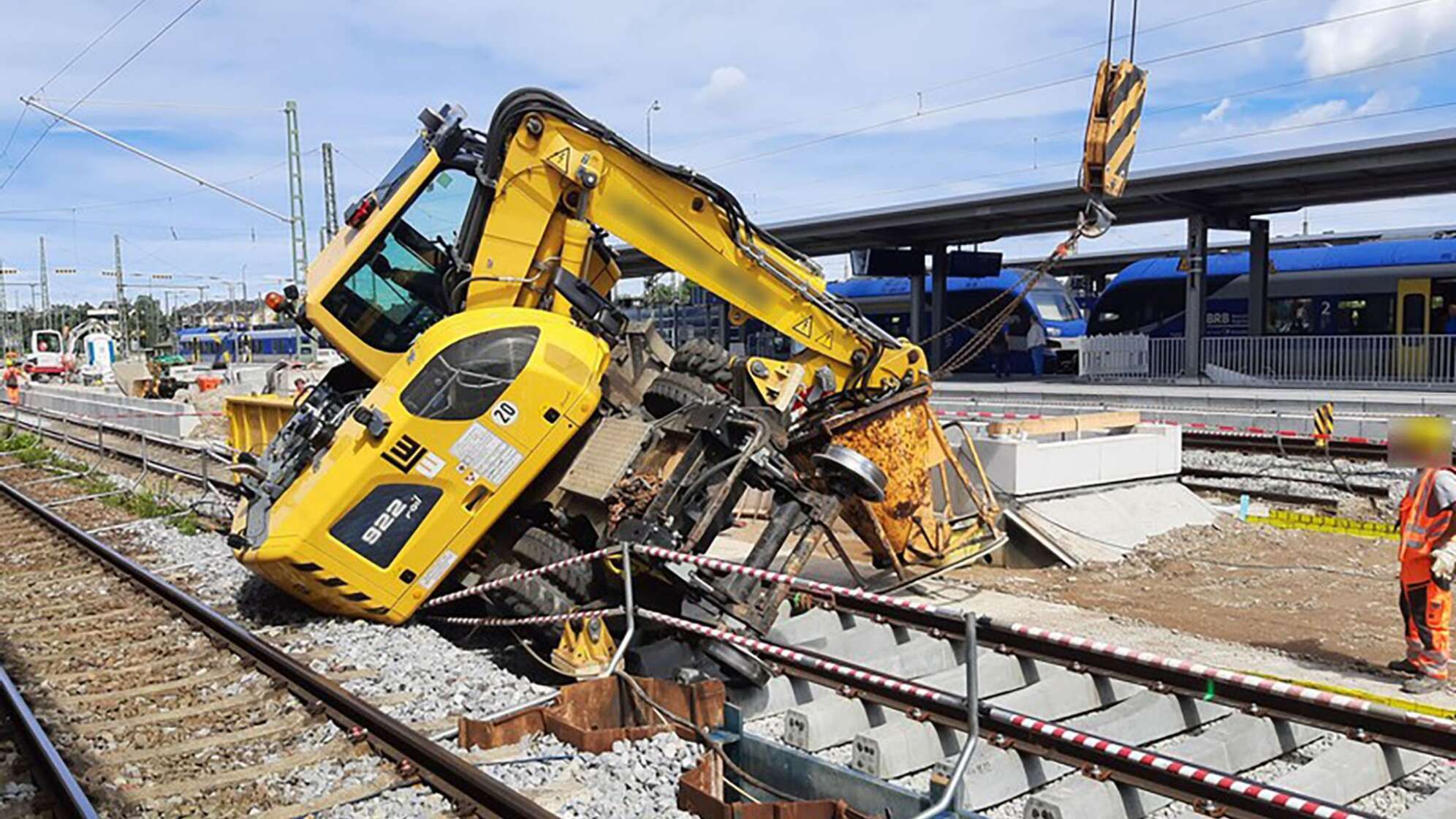 Bagger kippt am Bahnhof Freilassing auf Gleis