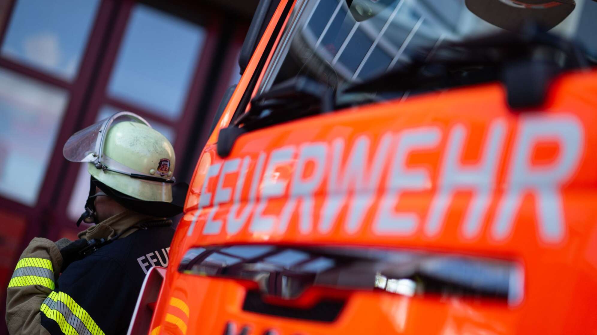 Feuerwehrmann steht neben einem Feuerwehrauto